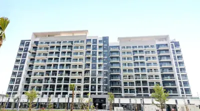 a tall building with palm trees in front of it at Studio Near Meydan Golf Club, 15-Minute Drive to Dubai Mall, Burj Khalifa and Downtown Attractions, Azizi Riviera 46, Al Merkadh by Deluxe Holiday Homes in Dubai