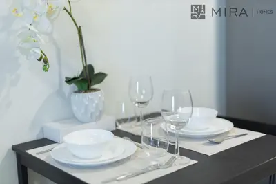 a table with plates and wine glasses on it at Mira Holiday Homes - Luxury, Stylish & Cozy Studio in Downtown Jebel Ali in Dubai