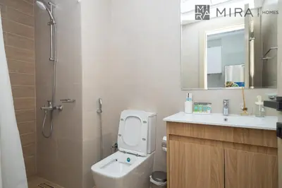 a bathroom with a toilet and a sink and a mirror at Mira Holiday Homes - Luxury, Stylish & Cozy Studio in Downtown Jebel Ali in Dubai