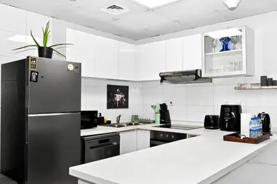 a kitchen with a refrigerator and a white counter top at Fantastic 2 Bed - Marina in Dubai