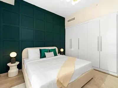 a bedroom with a white bed and a green wall at Breathtaking Sea View and Dubai Eye 2BR in Dubai