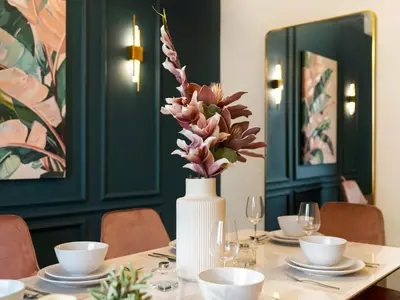 a table with a white vase with flowers in it at Breathtaking Sea View and Dubai Eye 2BR in Dubai