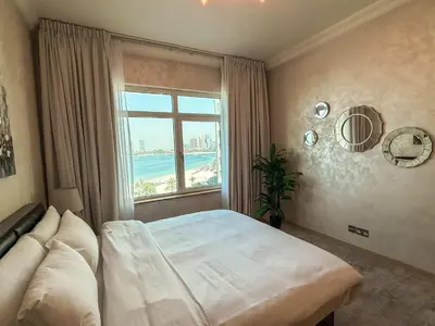 a bedroom with a bed and a large window at Sea View Beachfront 3BR Apartment - Shoreline 6 in Dubai