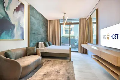 a bedroom with a bed and a couch and a tv at Modern Studio Elegant & Comfort in Dubai
