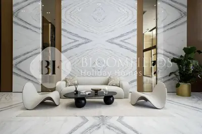 a living room with a white couch and a table at Bloomfields Cozy Stu Binghatti Azure in Dubai