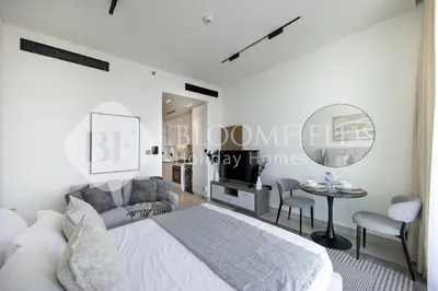 a bedroom with a bed and a tv and a table at Bloomfields Cozy Stu Binghatti Azure in Dubai
