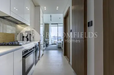a hallway leading to a kitchen with a view at Bloomfields Cozy Stu Binghatti Azure in Dubai