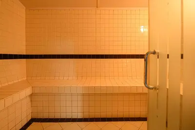an empty shower in a bathroom with white tiles at Luxurious 3BR with a pool table at Marina Walk in Dubai