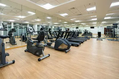 a gym with a lot of treadmills and ellipticals at Luxurious 3BR with a pool table at Marina Walk in Dubai