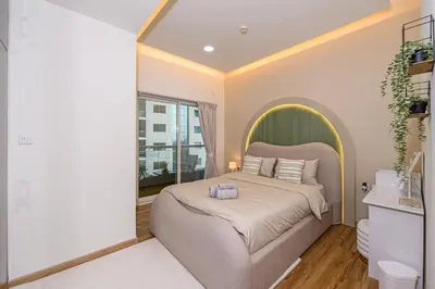 a bedroom with a large bed with a green headboard at Luxurious 3BR with a pool table at Marina Walk in Dubai