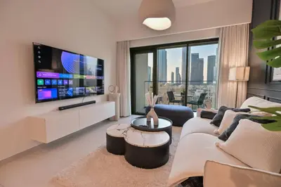 a living room with a couch and a tv at Full Burj Khalifa View, 3min Walk to Dubai Mall in Dubai