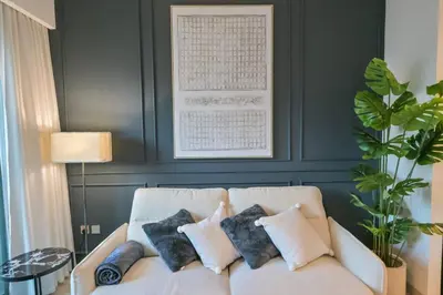 a living room with a white couch with pillows at Full Burj Khalifa View, 3min Walk to Dubai Mall in Dubai