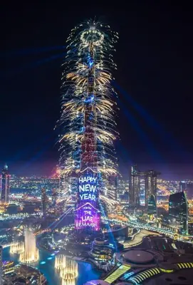 a lit up christmas tree in a city at night at Full Burj Khalifa View, 3min Walk to Dubai Mall in Dubai