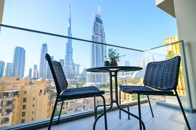 a table and chairs on a balcony with a view of a city at Full Burj Khalifa View, 3min Walk to Dubai Mall in Dubai