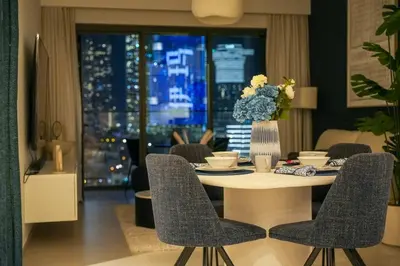 a dining room table with chairs and a vase of flowers at Full Burj Khalifa View, 3min Walk to Dubai Mall in Dubai
