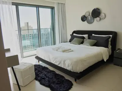 a bedroom with a large bed with a large window at Stylish-2BR, Burj Royale, 3 min walk to Dubai Mall in Dubai