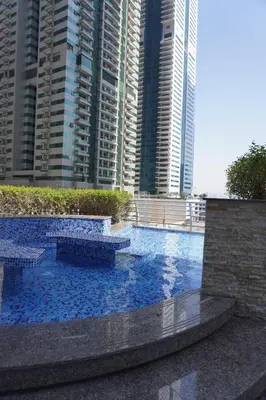 a large swimming pool in a city with tall buildings at Boho Style 2BHK Apartment With Sea View Next to Tram Station in Dubai