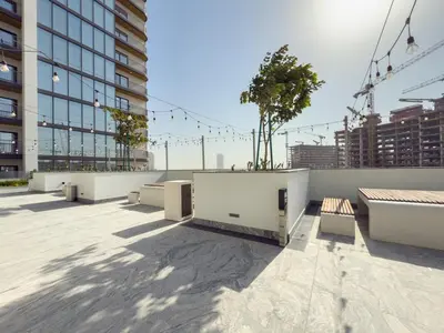 a rooftop of a building with benches and a tree at Modern Apartment with Balcony and Pool Access in Dubai