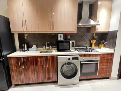 a kitchen with a washing machine and a microwave at Cozy Spacious Studio in Downtown with Burj Khalifa View in Dubai