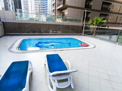 two chairs and a swimming pool on top of a building at Cozy Spacious Studio in Downtown with Burj Khalifa View in Dubai