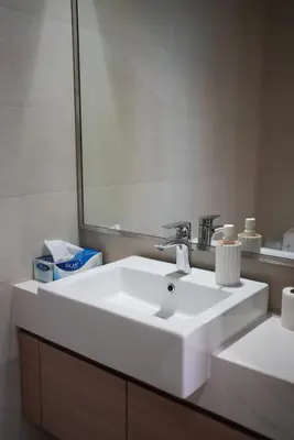 a bathroom with a white sink and a mirror at RIVIERA HOME ESCAPE 2BHK pool Gym in Dubai