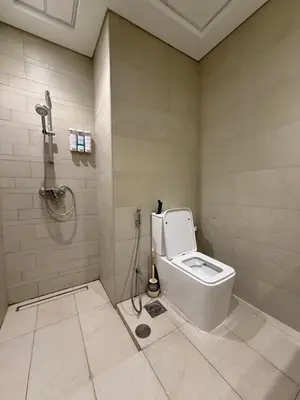 a bathroom with a toilet and a shower at RIVIERA HOME ESCAPE 2BHK pool Gym in Dubai