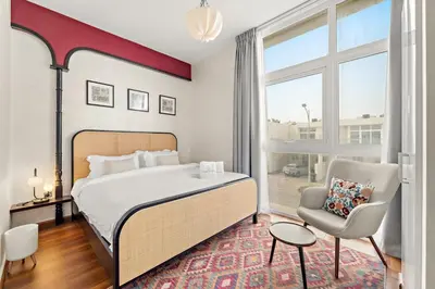 a bedroom with a bed and a chair and a window at FIRST CLASS VILLA Modern Comfort & Style in Dubai