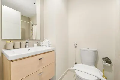 a bathroom with a white toilet and a sink at FIRST CLASS VILLA Modern Comfort & Style in Dubai