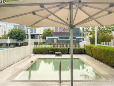 an umbrella over a pool in a yard at FIRST CLASS VILLA Modern Comfort & Style in Dubai