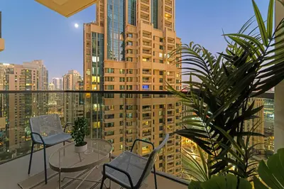 a balcony with chairs and tables and a view of a city at Spacious 1BR in Downtown with Balcony & Pool in Dubai