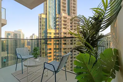 a balcony with chairs and a table and some plants at Spacious 1BR in Downtown with Balcony & Pool in Dubai