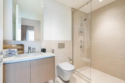 a bathroom with a shower and a toilet and a sink at Premium Creek Home Steps from the Lagoon in Dubai