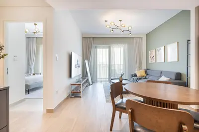 a living room with a table and a couch at Premium Creek Home Steps from the Lagoon in Dubai
