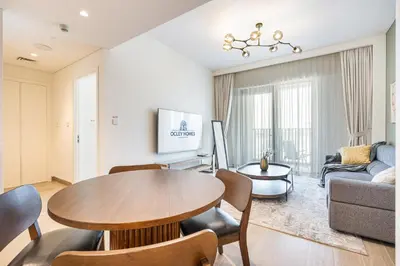 a living room with a table and a couch at Premium Creek Home Steps from the Lagoon in Dubai
