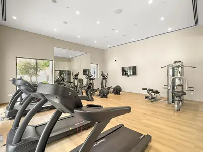 a gym with treadmills and ellipticals in a room at FIRST CLASS 1BR Creek Beach , Relaxing Vibes in Dubai