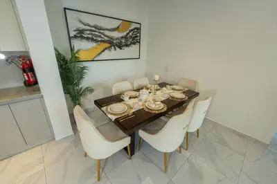 a dining room with a table and white chairs at Business Bay 1BR Burj Khalifa&Canal Views,3Balcony in Dubai