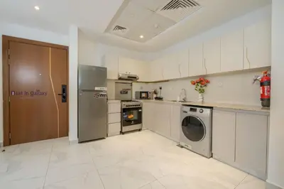 a kitchen with a refrigerator and a washer and dryer at Business Bay 1BR Burj Khalifa&Canal Views,3Balcony in Dubai