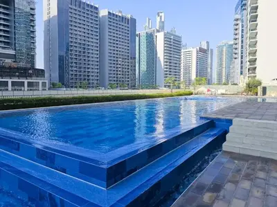 a pool in the middle of a city with tall buildings at FIRST CLASS 1BR Canal View Escape in Dubai