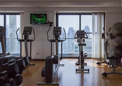 a gym with exercise equipment and a large window at Cosmos Living Delightful Studio in Dubai