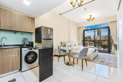 a kitchen and living room with a sink and a washing machine at FIRST CLASS Studio Stylish & Cozy JVC Escape in Dubai
