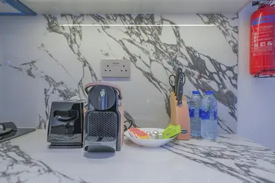 a kitchen counter with a toaster and a toaster and some bottles at EasyGo - Modern 1BR with Balcony & Amenities in Arjan in Dubai