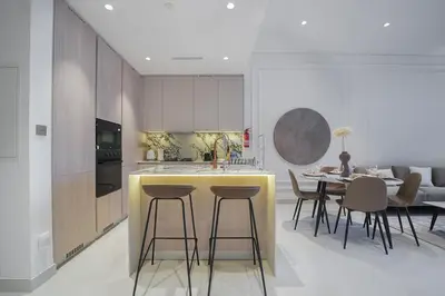 a kitchen with a counter and a table with chairs at EasyGo - Modern 1BR with Balcony & Amenities in Arjan in Dubai
