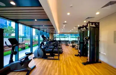 a gym with treadmills and ellipticals in a building at Cosy flat in the heart of Dubai in Dubai