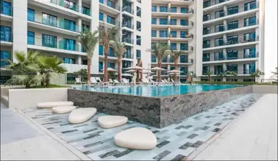 a swimming pool in front of a large building at Cosy flat in the heart of Dubai in Dubai