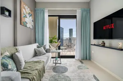 a living room with a couch and a tv at Cosy flat in the heart of Dubai in Dubai