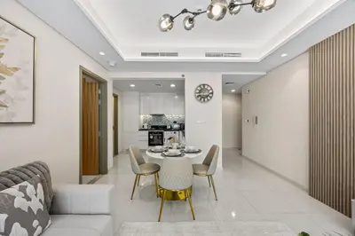 a living room and dining room with a table and chairs at Paramount Midtown, Luxury 1BR with Infinity Pool with Burj View in Dubai