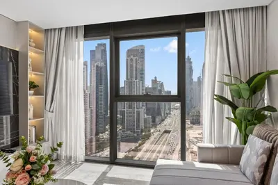 a living room with a view of a city at Paramount Midtown, Luxury 1BR with Infinity Pool with Burj View in Dubai