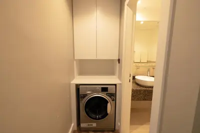 a washing machine in a bathroom with a white cabinet at Full Sea View Luxury Large 1 BR in JBR in Dubai
