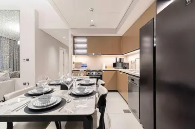 a kitchen with a table with wine glasses on it at Two Identical Apartments - Same Building in Dubai