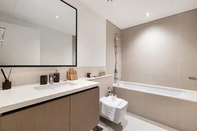 a bathroom with a toilet and a sink and a tub at Two Identical Apartments - Same Building in Dubai